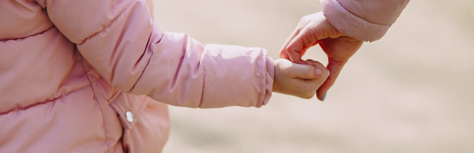 zu sehen ist eine Kinderhand und eine Hand eines Erwachsenen, die sich festhalten