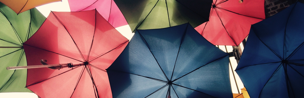 Zu sehen sind einige bunte Regenschirme von unten fotografiert.