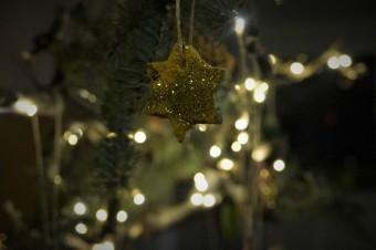 zu sehen ist ein gebastelter gelber Stern aus Salzteig am Weihnachtsbaum