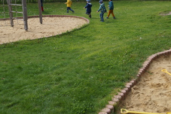 zu sehen ist eine Grasfläche mit rennenden Kindern