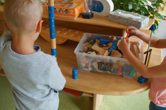 zu sehen sind zwei Kinder, die mit Magnetsteinen Türme bauen