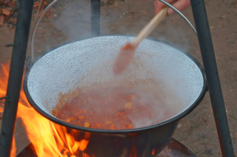 zu sehen ist Kesselgulasch in einem Topf über dem Feuer