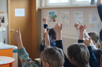 zu sehen sind mehrere Kinderhände, die den Daumen hochstrecken