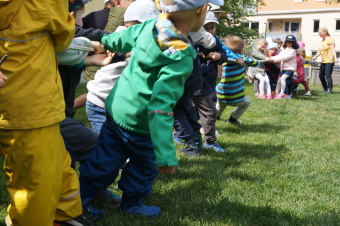 zu sehen sind Kinder die entgegengesetzt an einem Seil ziehen