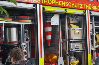 zu sehen ist ein Feuerwehrauto mit geöffneten Seitenflächen. Innen sind die Geräte zur Brandbekämpfung zu sehen