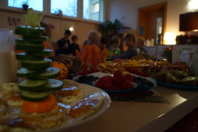 zu sehen sind diverse Teller mit Essen. Im Vordergrund steht ein aus Gurken gestapelter Weihnachtsbaum