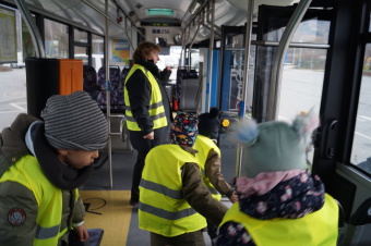 zu sehen sind Kinder und eine erwachsene Person in einem Bus