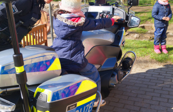 zu sehen ist ein Kind auf einem Polizeimotorrad
