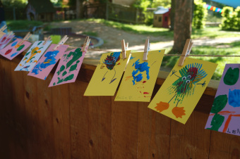zu sehen sind von Kindern gemalte bunte Blätter, auf denen kleine Farbmonster zu sehen sind.