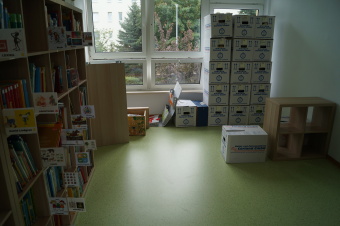 zu sehen ist ein Raum mit vielen Kisten und neuem grünem Fußboden