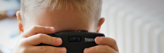zu sehen ist ein Kind, dass durch eine Kamera schaut