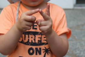 ein Kind zählt mithilfe seiner Finger ab