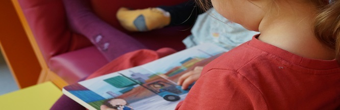 zu sehen ist ein Kind, dass sich ein Buch ansieht