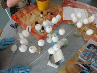zu sehen sind viele weiße Eier auf Stöcken auf einem Tisch stehen