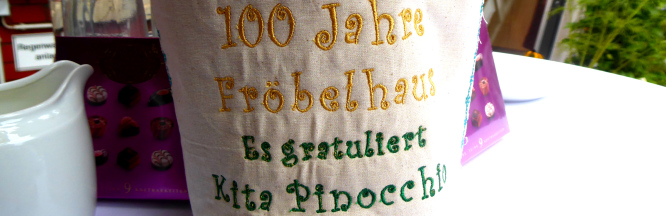 zu sehen ist der gestickte Schriftzug: "100 Jahre Föbelhaus, es gratuliert Kita Pinocchio" 