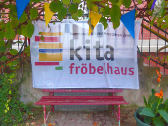 zu sehen ist das Banner der Kita Fröbelhaus mit der Aufschrift: Kommunale Kindertagestätten Jena, Kita Fröbelhaus 