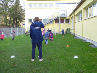 zu sehen sind Kinder, die rennen. Ein Mann in einer Jacke, mit der Aufschrift "FC Carl Zeiss Jena" steht im Vordergrund